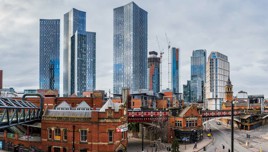 Panoramic view of Manchester skyline with tall modern buildings and historic architecture.