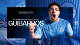 A person in a Manchester City Esports shirt with the text 'Welcome to City' and 'Guibarras Plays' overlaid. The design includes logos of Manchester City Esports and Etisalat. The shirt features blue stripes.