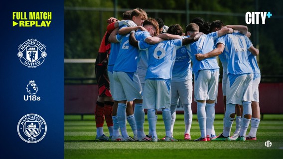 Group of Manchester City U18 players in light blue jerseys huddle on the field before a match against Manchester United.