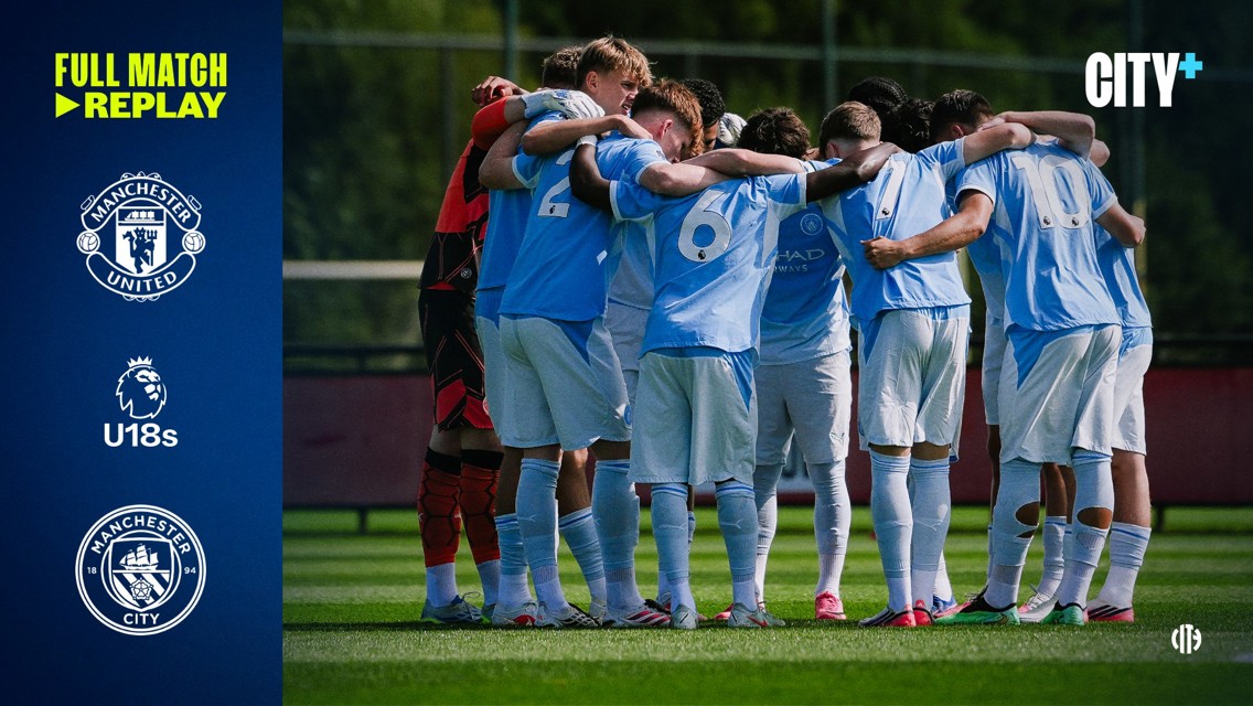 Group of Manchester City U18 players in light blue jerseys huddle on the field before a match against Manchester United.