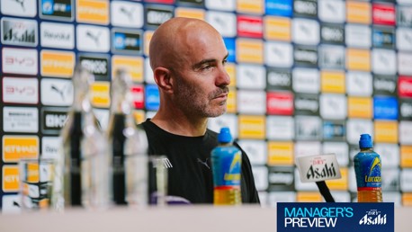 A person sitting at a press conference with background sponsor logos and two bottles on the table. The text 'Manager's Preview' is visible in the bottom right corner.