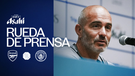 Press conference image featuring a person with logos of Arsenal and Manchester City alongside text 'Rueda de Prensa' and 'Asahi Super Dry'.