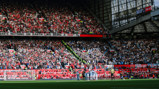Football match at Old Trafford between Manchester United and Manchester City with a crowded stadium and fans wearing club colors.