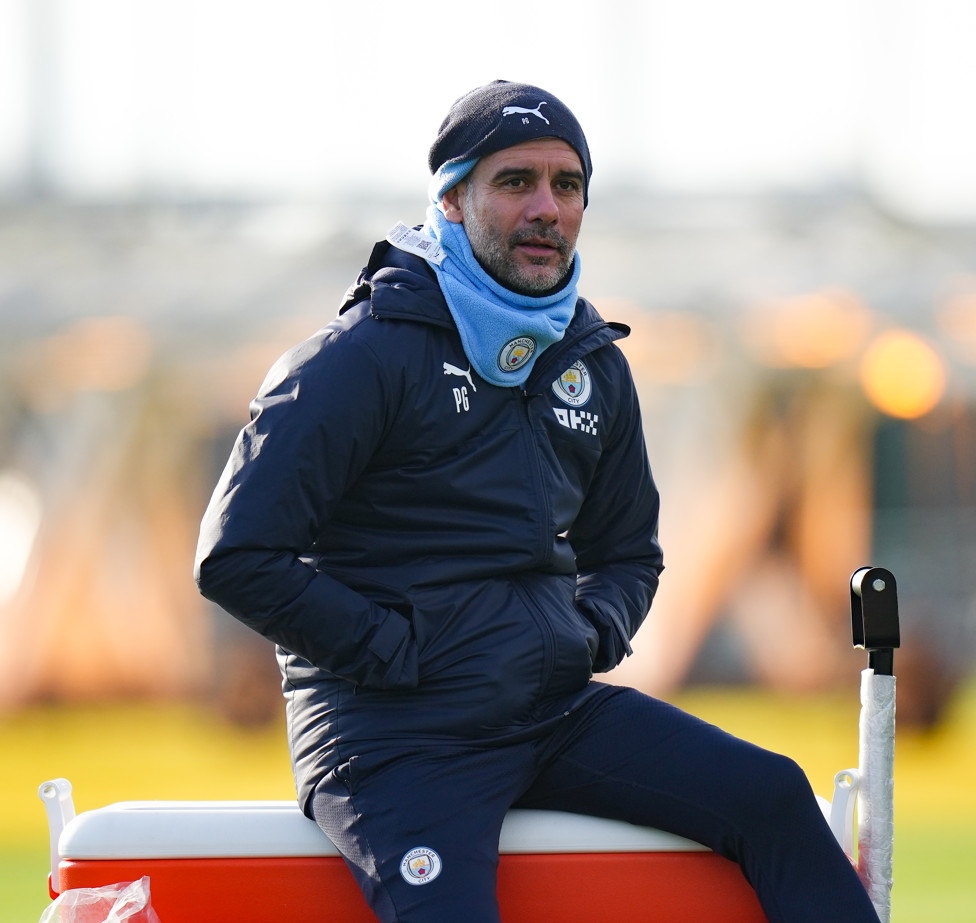 AGASALHADO : Pep comanda o treino em meio ao frio. 