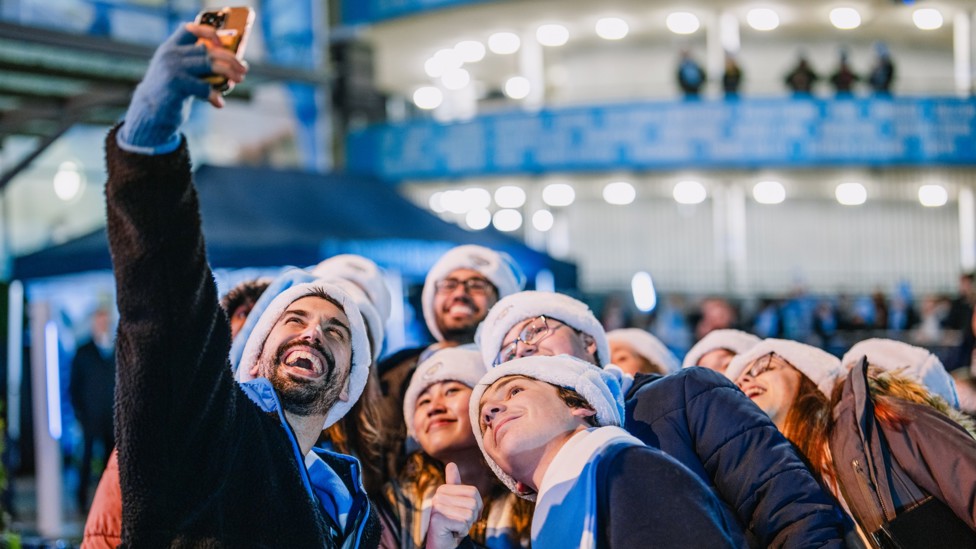 ALL SMILES : Fans spreading festive cheer outside the stadium.