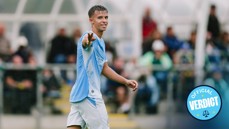 A football player pointing towards the camera while wearing a light blue and white kit, with a badge that says 'Official Verdict'.