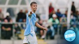 A football player pointing towards the camera while wearing a light blue and white kit, with a badge that says 'Official Verdict'.