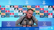 Person at UEFA Women's Champions League press conference podium with sponsor logos in the background.