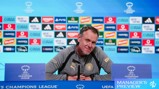 Person at UEFA Women's Champions League press conference podium with sponsor logos in the background.