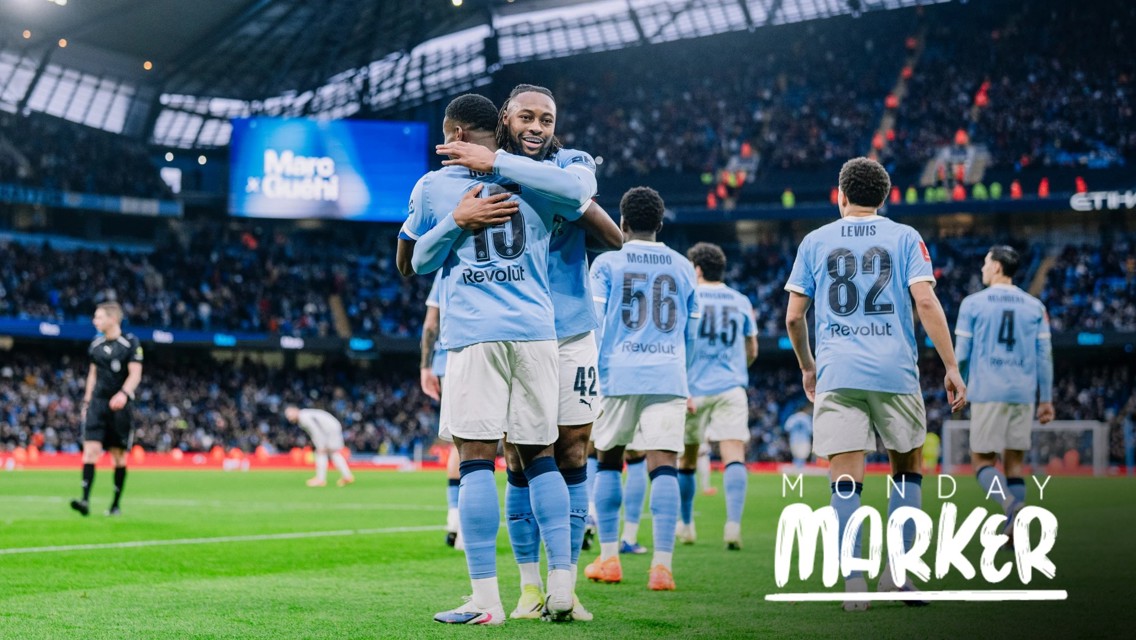 Manchester City players celebrating a goal at Etihad Stadium, player names like Lewis, McAidoo visible on jerseys. Crowd in the background, Monday Marker text on image.