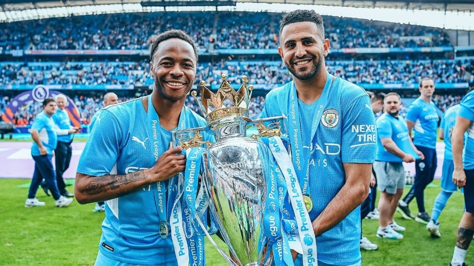 SILVERWARE : The winger celebrates a third Premier League title at City alongside Raheem Sterling in May 2022.