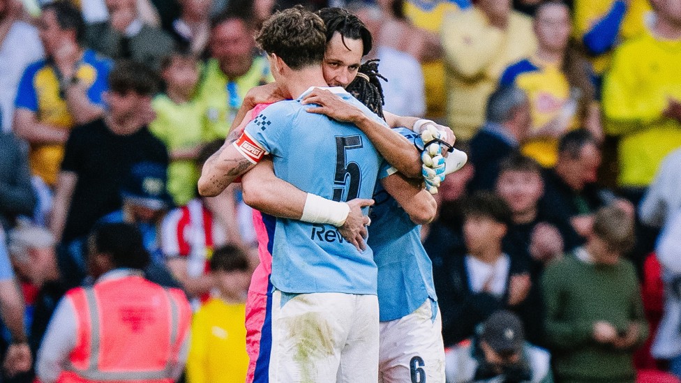 LEAN ON ME: James Trafford and John Stones share an embrace after securing the FA Cup trophy