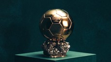 A gold Ballon d'Or trophy labeled 'FRANCE FOOTBALL 2024' with a hexagonal pattern on a crystalline base.