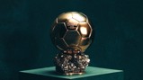 A gold Ballon d'Or trophy labeled 'FRANCE FOOTBALL 2024' with a hexagonal pattern on a crystalline base.