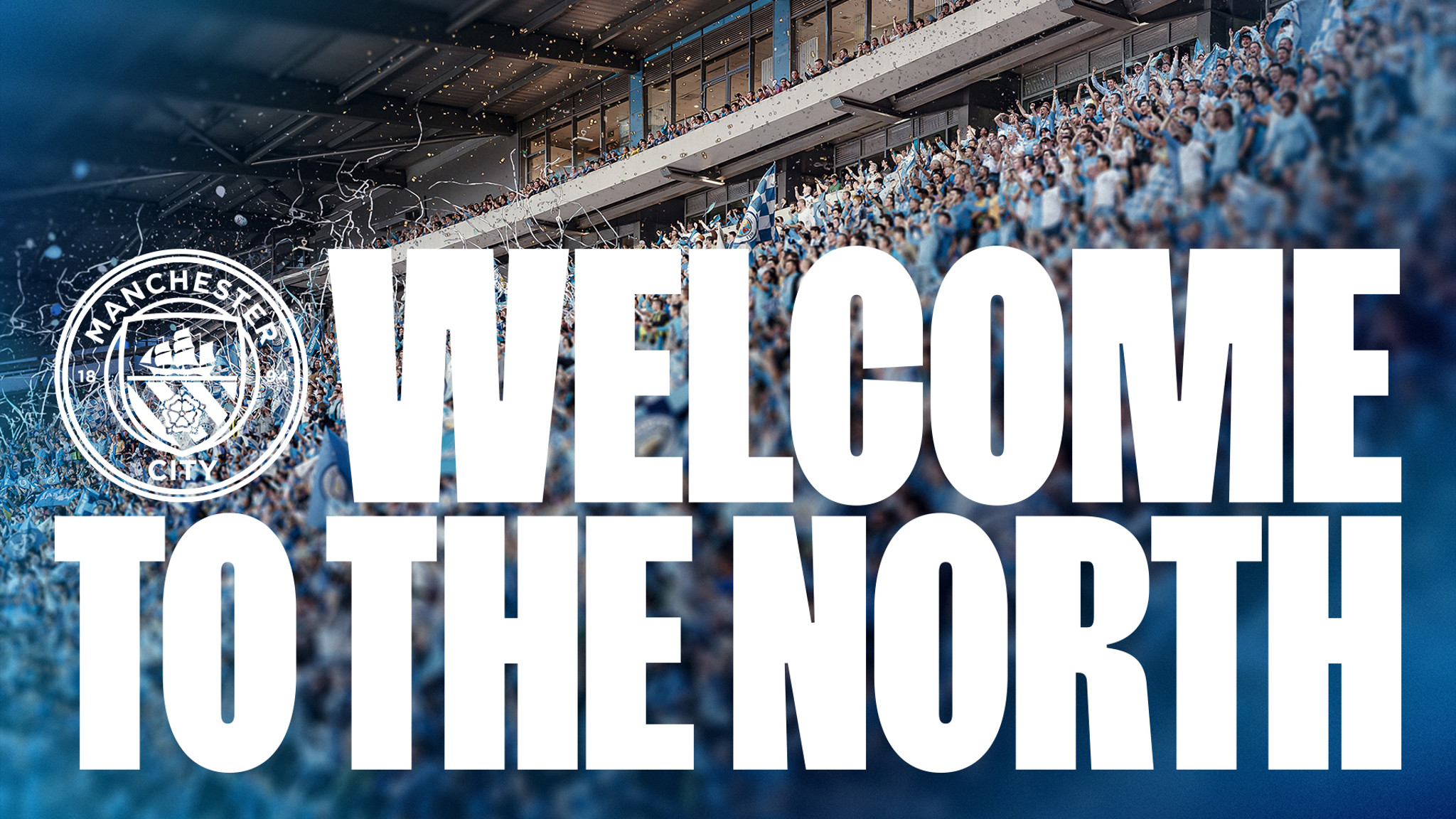 A Manchester City banner with the text 'WELCOME TO THE NORTH' in bold letters against a stadium crowd background showing the Manchester City logo.