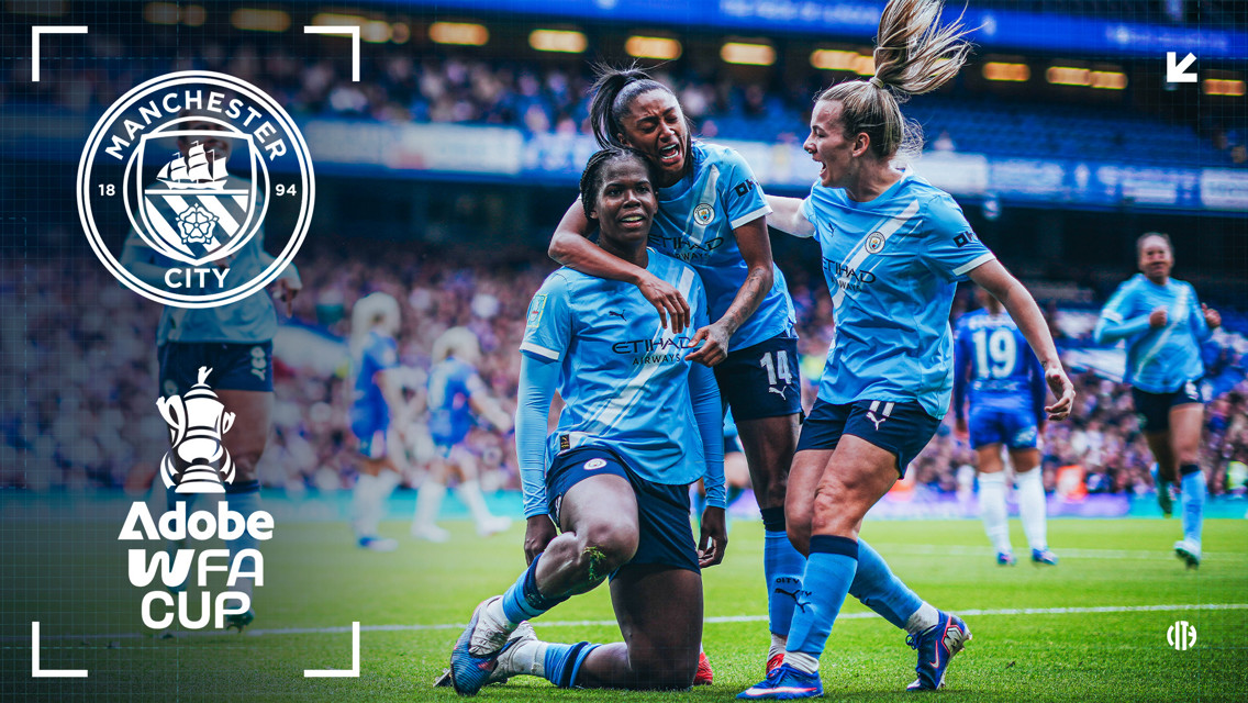 Image showing Manchester City Women's team celebrating during a match, featuring the team's logo and Adobe Women's FA Cup icon. The players are wearing light blue kits, and the stadium is filled with spectators.