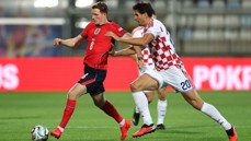 Two soccer players in action during a match. One player is wearing a red England kit, and the other is in a white and red Croatia kit.