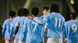 A group of football players wearing blue jerseys with numbers 7, 11, and 9, likely from a Manchester City team, walking together with one player's arm around another.