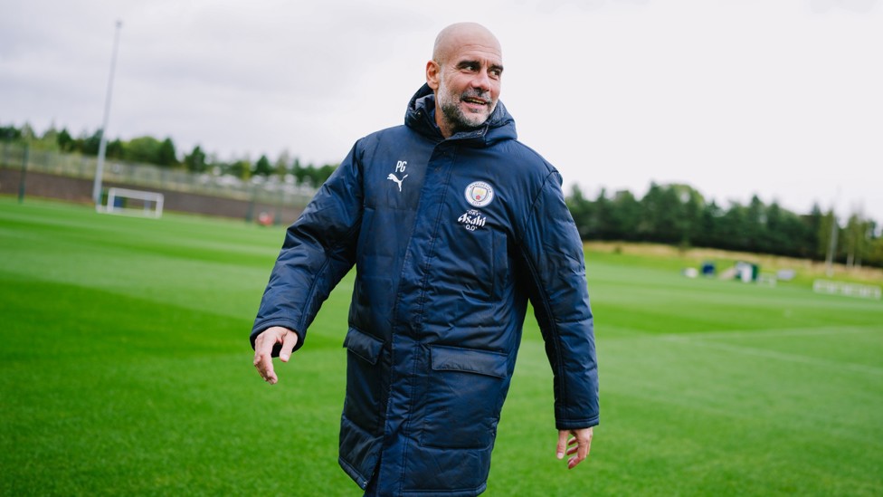WRAPPED UP  : Pep Guardiola prepared for the wet and windy weather!