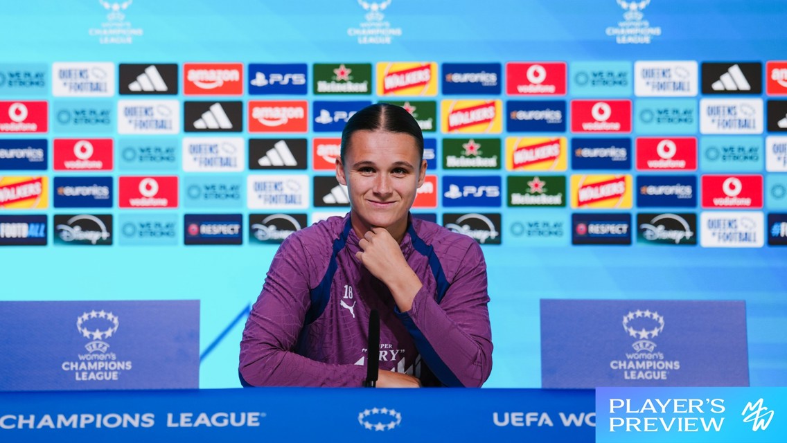 A person in a purple uniform sits at a press conference table with a UEFA Women’s Champions League logo. Behind are sponsor logos including Adidas, Heineken, PayPal, and Disney.