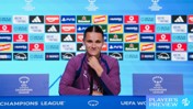 A person in a purple uniform sits at a press conference table with a UEFA Women’s Champions League logo. Behind are sponsor logos including Adidas, Heineken, PayPal, and Disney.