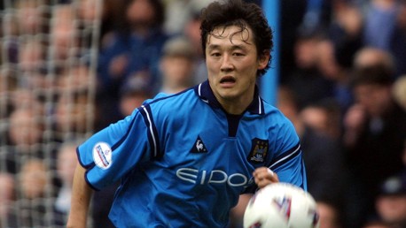 A player wearing a blue Manchester City jersey in action against an opposing team during a football match.