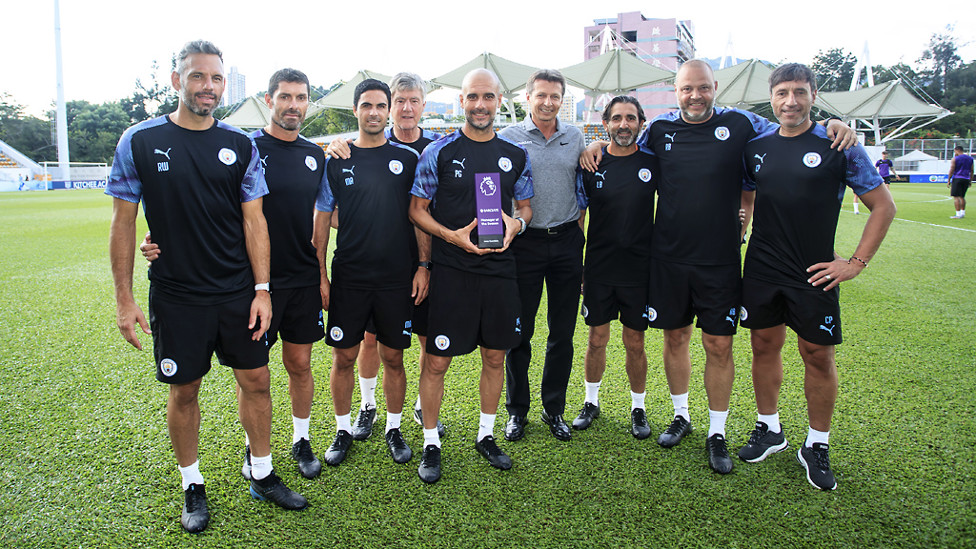 PRIZE GUYS : Pep Guardiola proudly holds aloft the 2019 manager of the year award along with members of the City coaching team