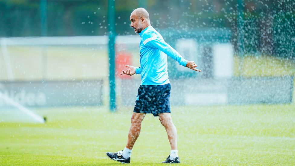 WATCH OUT : Pep gets a refreshing spray from the sprinklers on a warm day in Manchester.