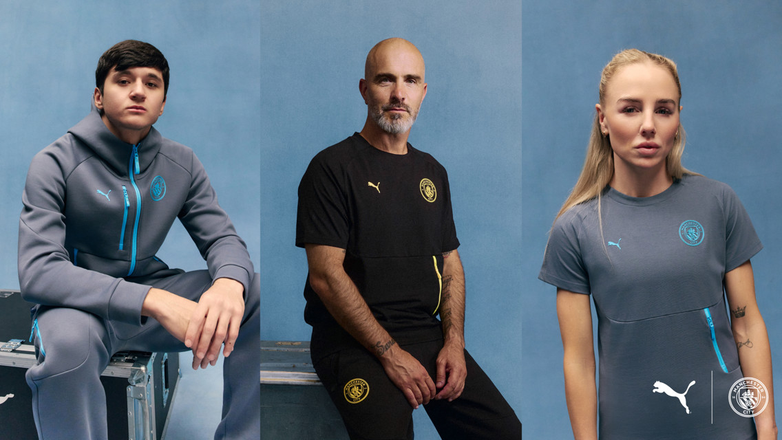 Three individuals modeling Manchester City and Puma apparel against a blue background.