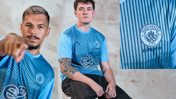 Esports players wearing a blue Manchester City jersey with esports logo.