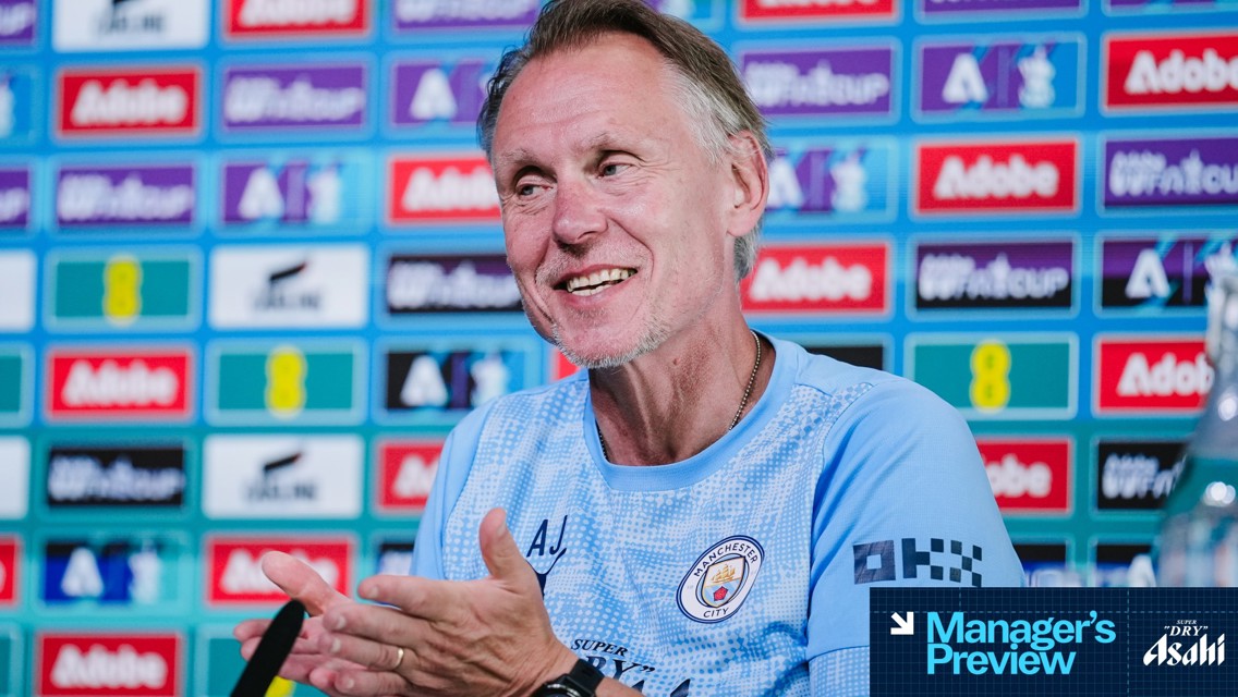 A person in a Manchester City shirt is clapping during a press conference. Behind them is a wall with various logos including Adobe. The image has a 'Manager's Preview' graphic in the corner.