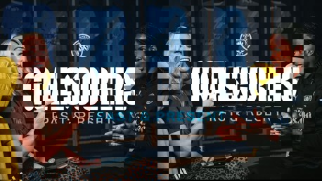 Two individuals in conversation with Manchester City shirts displayed in the background. Text reads 'Goalscorers Past & Present' with the Manchester City logo above.