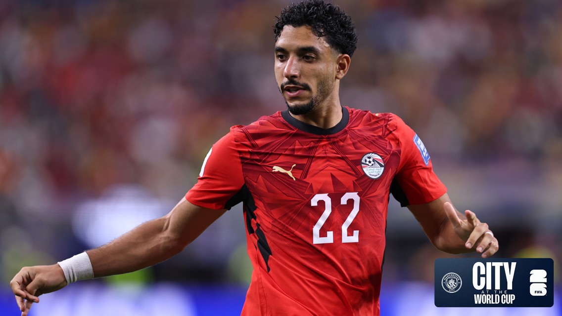 A football player in a red Egyptian national team jersey with Puma logo, number 22, wearing a white wristband at a World Cup event.