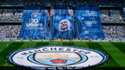 A large Manchester City banner celebrating 10 years with Pep displayed in a stadium, featuring slogans like 'Game Changer' and 'City Forever'.