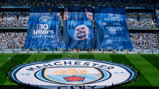 A large Manchester City banner celebrating 10 years with Pep displayed in a stadium, featuring slogans like 'Game Changer' and 'City Forever'.